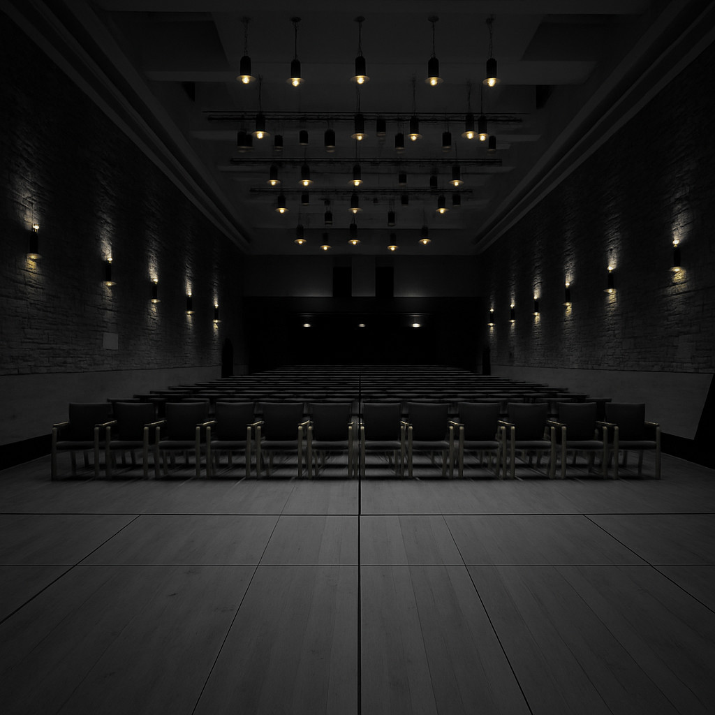 Cinematic black-and-white image of the Budapest Music Center concert hall, featuring minimalist wooden architecture, stone walls, and softly glowing wall and ceiling lights.